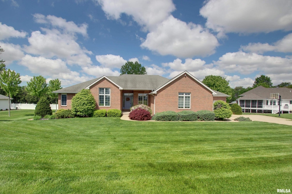 single story home featuring brick siding and a front yard