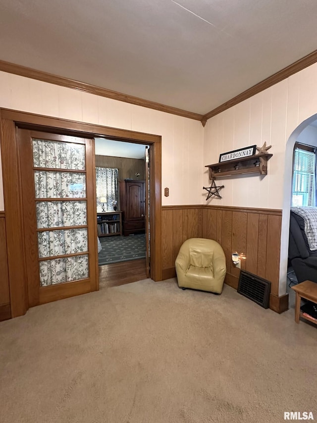 277 N Ivan Ave, Galesburg, IL 61401 - living area with ornamental molding, arched walkways, carpet flooring, and wooden walls