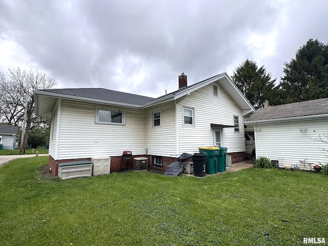 277 N Ivan Ave, Galesburg, IL 61401 - rear view of house with a yard, a chimney, and central AC