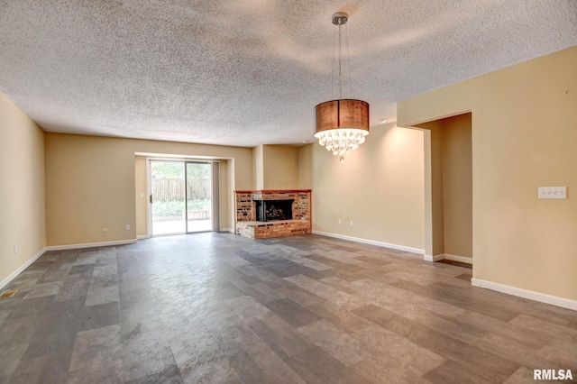 2628 S Forrest Green Dr, Decatur, IL 62521 - unfurnished living room with a textured ceiling, a fireplace, and a chandelier
