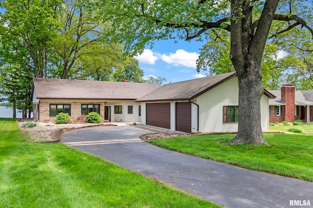 188 E Hazel Dell Ln, Springfield, IL 62712 - view of front of home featuring an attached garage, driveway, a front lawn, and a chimney