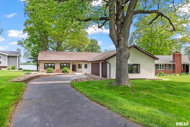 188 E Hazel Dell Ln, Springfield, IL 62712 - view of front facade featuring asphalt driveway, a garage, a front yard, a chimney, and brick siding