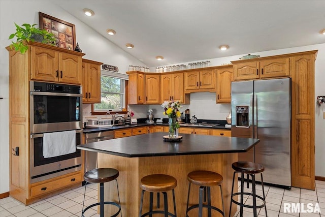 1405 Woods Farm Ln, Springfield, IL 62704 - kitchen with stainless steel appliances, light tile patterned flooring, dark countertops, lofted ceiling, and a breakfast bar