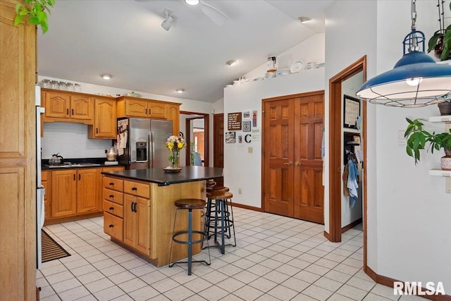 1405 Woods Farm Ln, Springfield, IL 62704 - kitchen with stainless steel fridge, vaulted ceiling, a breakfast bar, dark countertops, and light tile patterned flooring