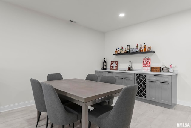 321 Harbor Point Pl, Springfield, IL 62712 - dining space with bar with sink, light wood-style flooring, baseboards, and recessed lighting