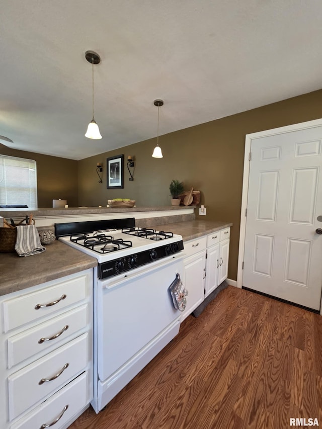 514 W Washington St, Mendon, IL 62351 - kitchen with white gas range oven, dark wood-style floors, white cabinets, and pendant lighting