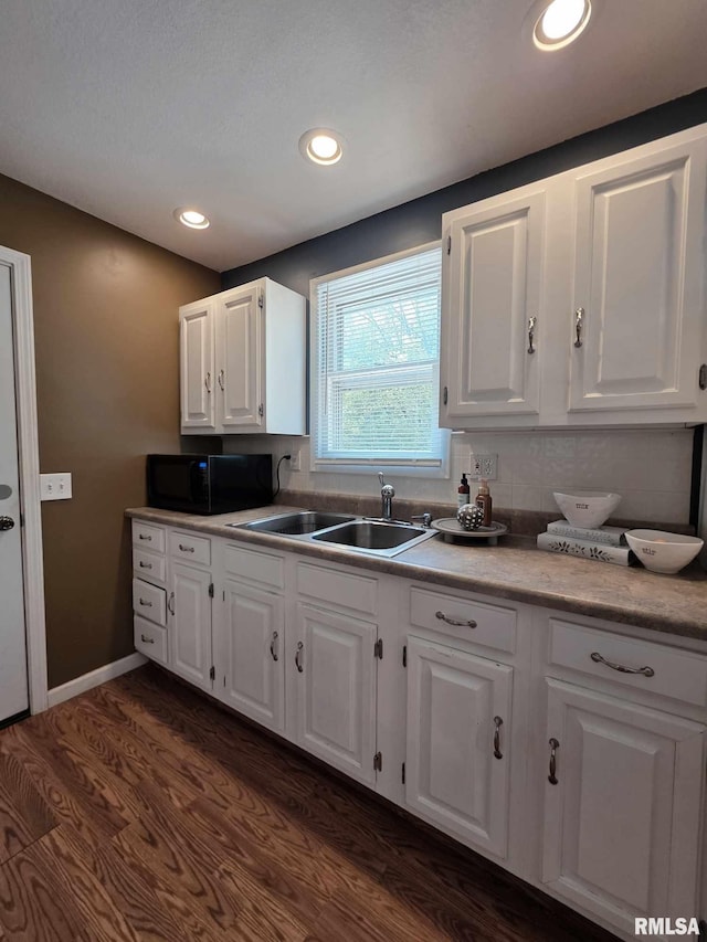 514 W Washington St, Mendon, IL 62351 - kitchen with black microwave, a sink, dark wood-type flooring, white cabinets, and light countertops