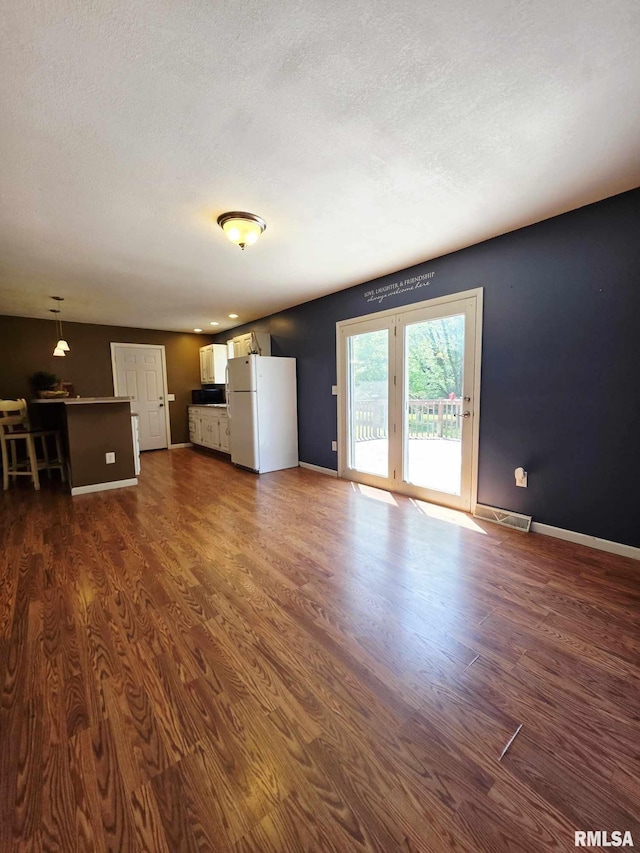 514 W Washington St, Mendon, IL 62351 - unfurnished living room with dark wood-type flooring, baseboards, and a textured ceiling