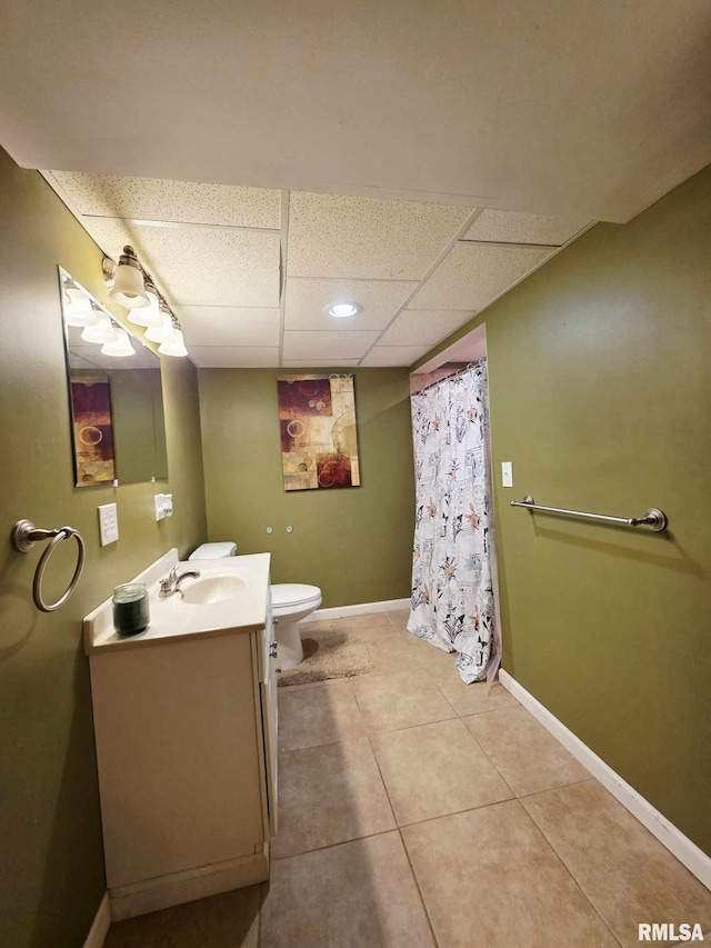 514 W Washington St, Mendon, IL 62351 - bathroom featuring toilet, a paneled ceiling, vanity, baseboards, and tile patterned flooring