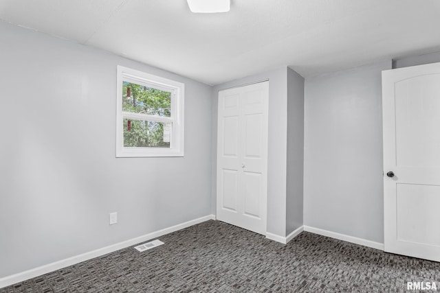 unfurnished bedroom with carpet floors, a closet, and baseboards