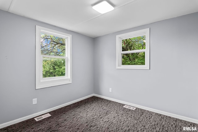 spare room with baseboards and carpet flooring