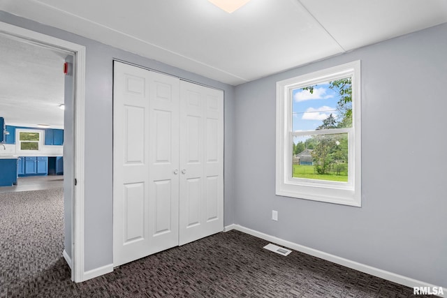unfurnished bedroom with carpet flooring, baseboards, and a closet