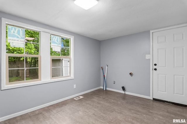clothes washing area featuring wood finished floors and baseboards