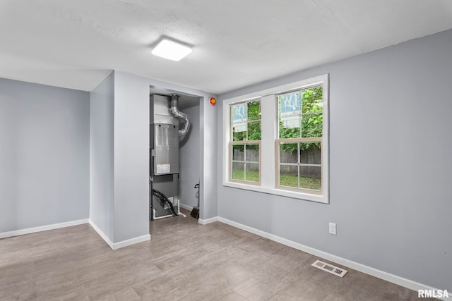 unfurnished bedroom featuring baseboards, wood finished floors, and a closet