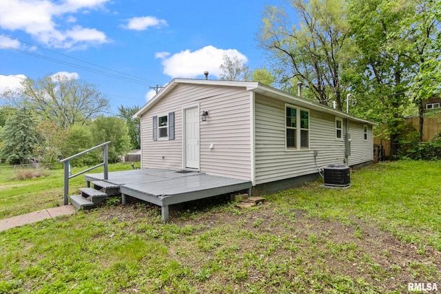 back of house with a wooden deck, a lawn, and central AC unit