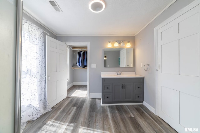 309 W State St, Payson, IL 62360 - full bathroom featuring wood finished floors, ornamental molding, baseboards, vanity, and a spacious closet