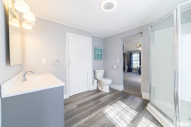309 W State St, Payson, IL 62360 - bathroom with wood finished floors, a stall shower, vanity, a ceiling fan, and toilet