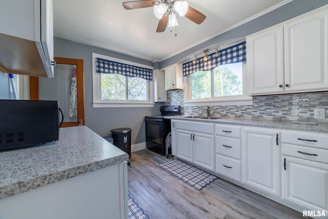 309 W State St, Payson, IL 62360 - kitchen featuring black appliances, a sink, light countertops, backsplash, and light wood-type flooring