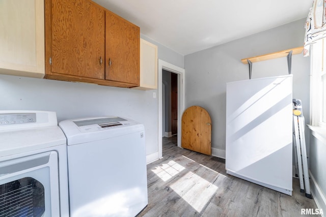 309 W State St, Payson, IL 62360 - laundry area featuring cabinet space, separate washer and dryer, light wood-style flooring, and baseboards