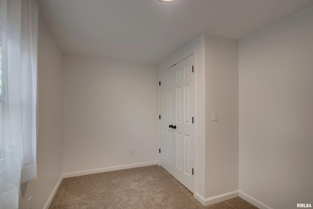 unfurnished bedroom with carpet floors, baseboards, and a closet