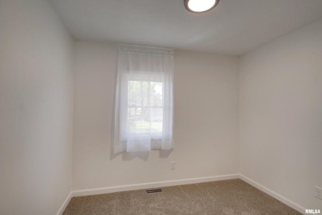 empty room featuring carpet and baseboards