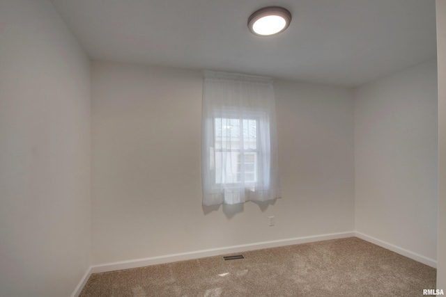 carpeted empty room featuring baseboards