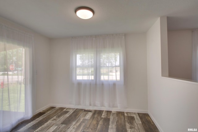 spare room with wood finished floors and baseboards