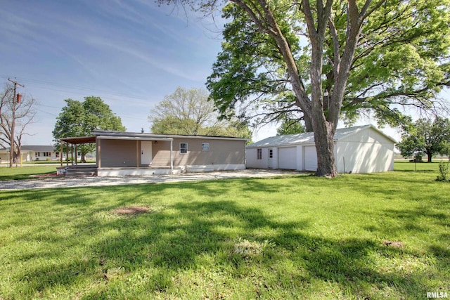 back of property featuring a detached garage, a lawn, and an outbuilding