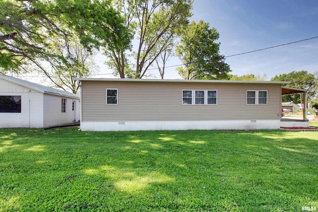 rear view of house with crawl space and a yard
