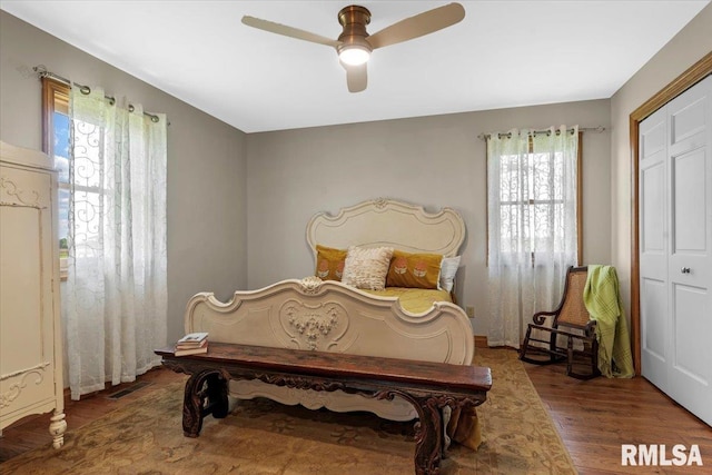 bedroom featuring multiple windows, wood finished floors, and ceiling fan