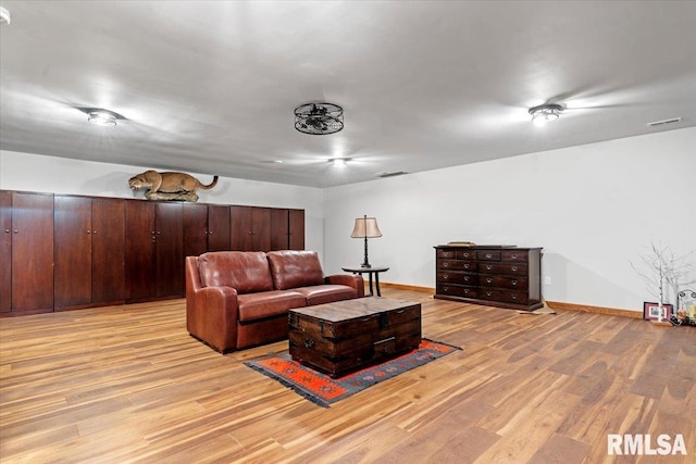 living area featuring light wood-style flooring and baseboards