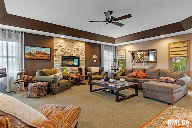 living room with light carpet, a ceiling fan, plenty of natural light, a tray ceiling, and recessed lighting