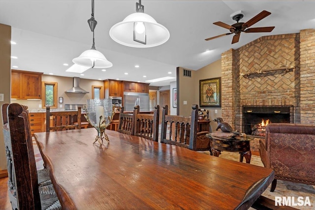 dining room featuring a ceiling fan, lofted ceiling, a brick fireplace, and recessed lighting