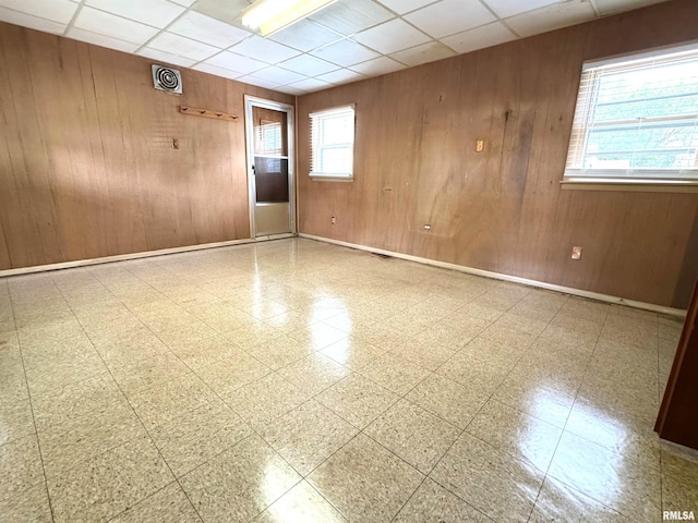 461 W Fremont St, Galesburg, IL 61401 - spare room featuring wooden walls, a drop ceiling, tile patterned floors, and baseboards