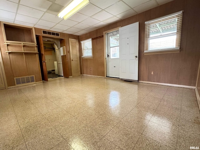 461 W Fremont St, Galesburg, IL 61401 - empty room featuring wood walls, baseboards, a paneled ceiling, and tile patterned floors