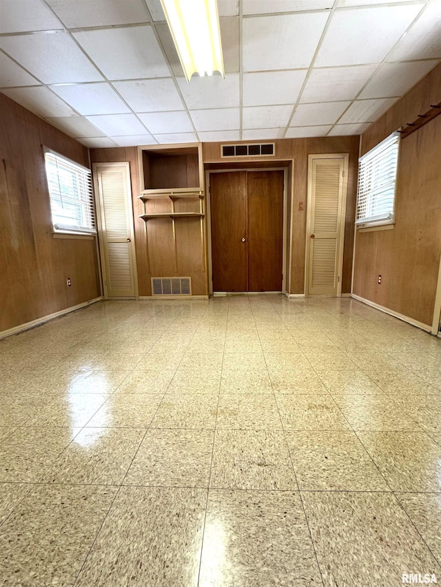 461 W Fremont St, Galesburg, IL 61401 - unfurnished room featuring wooden walls, a drop ceiling, and baseboards