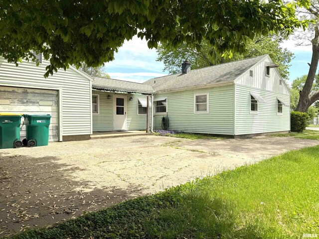 461 W Fremont St, Galesburg, IL 61401 - view of front of home featuring a garage, a chimney, concrete driveway, and roof with shingles