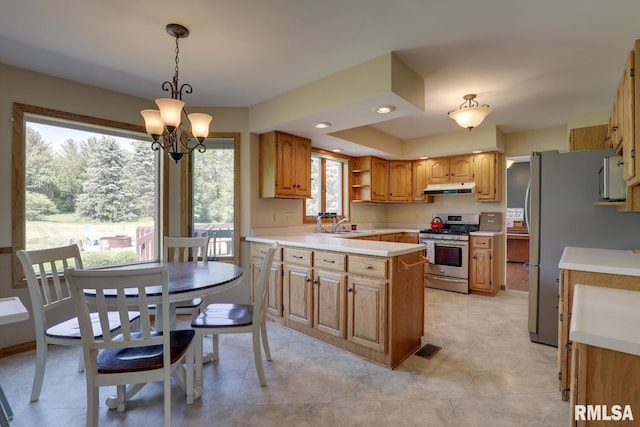 4629 Hidden Cove Rd, Quincy, IL 62305 - kitchen with stainless steel gas stove, under cabinet range hood, a chandelier, light countertops, and hanging light fixtures