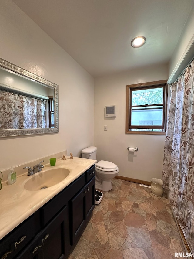 810 NW 7th Ave, Galva, IL 61434 - bathroom featuring toilet, vanity, and stone finish flooring