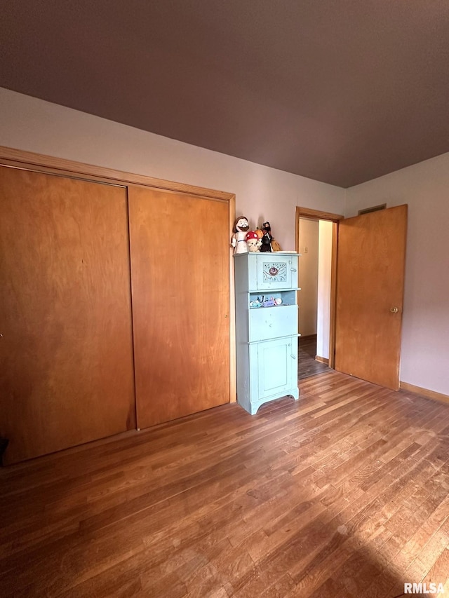 810 NW 7th Ave, Galva, IL 61434 - unfurnished bedroom featuring wood finished floors and a closet