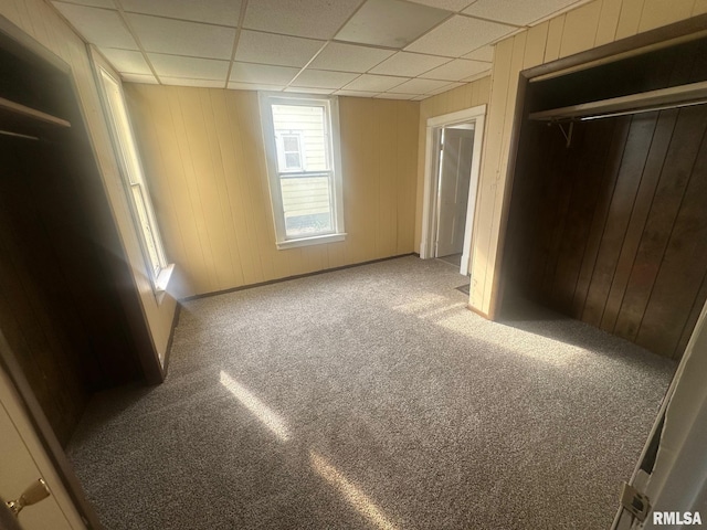859 Mulberry St, Galesburg, IL 61401 - unfurnished bedroom featuring carpet flooring, a drop ceiling, a closet, and wooden walls