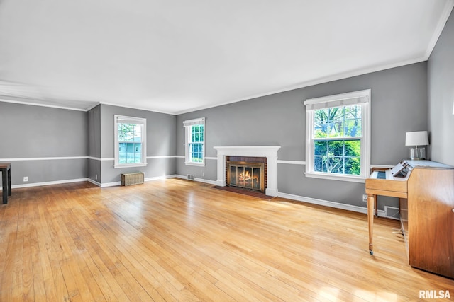 2255 N Broad St, Galesburg, IL 61401 - unfurnished living room featuring hardwood / wood-style flooring, crown molding, a fireplace with flush hearth, and baseboards