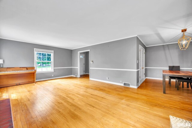 2255 N Broad St, Galesburg, IL 61401 - unfurnished living room featuring light wood-style flooring, baseboards, and ornamental molding