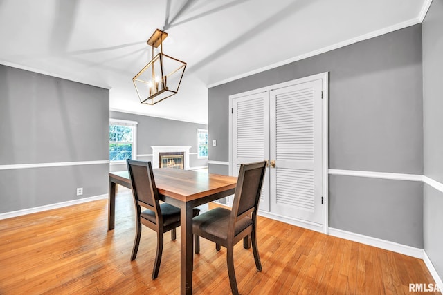 2255 N Broad St, Galesburg, IL 61401 - dining space with baseboards, a chandelier, light wood-style floors, ornamental molding, and a glass covered fireplace