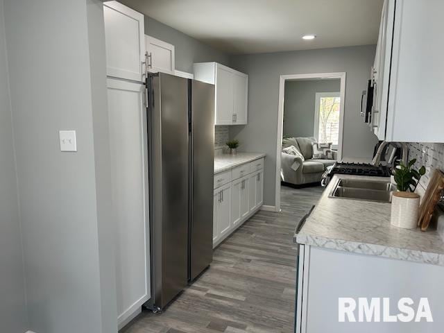 818 Van Buren St, Quincy, IL 62301 - kitchen with stainless steel appliances, white cabinets, backsplash, and wood finished floors