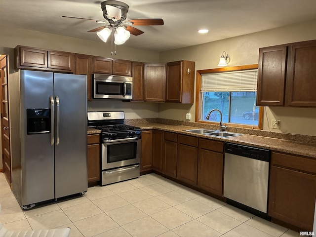 1744 Jackson St, Quincy, IL 62301 - kitchen featuring stainless steel appliances, a sink, dark countertops, a ceiling fan, and light tile patterned flooring