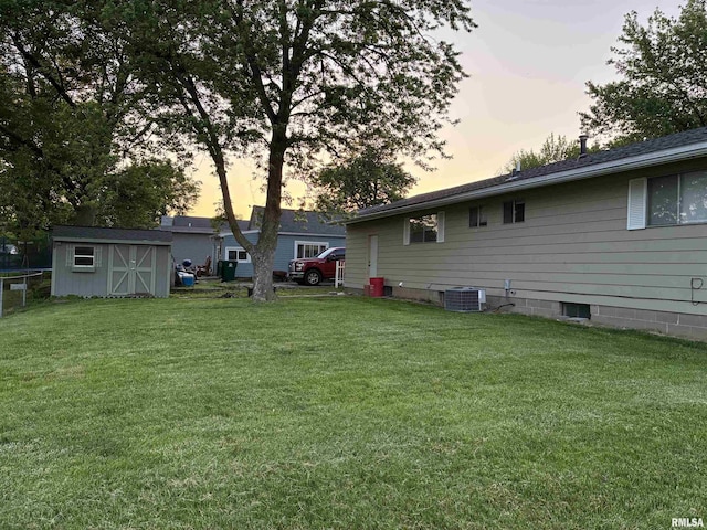 1744 Jackson St, Quincy, IL 62301 - yard at dusk featuring a shed, an outdoor structure, a yard, and central AC
