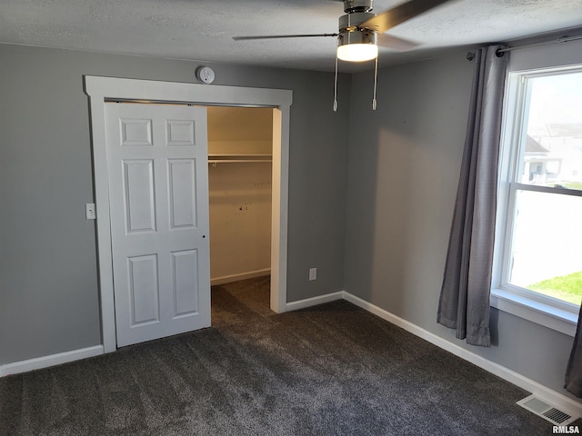 718 Adams St, Quincy, IL 62301 - unfurnished bedroom with dark carpet, a textured ceiling, baseboards, ceiling fan, and a closet