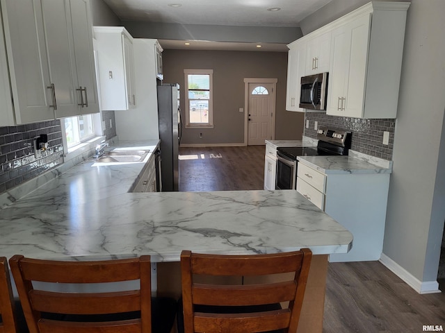 718 Adams St, Quincy, IL 62301 - kitchen featuring appliances with stainless steel finishes, dark wood-style floors, baseboards, a sink, and tasteful backsplash