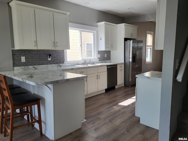 718 Adams St, Quincy, IL 62301 - kitchen featuring stainless steel fridge with ice dispenser, dishwasher, a peninsula, dark wood-style flooring, and white cabinetry